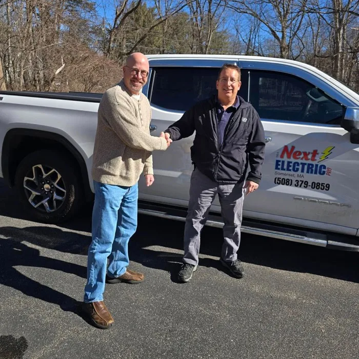 Raymond Melanson shaking hands with Paul Lavallee in front of a Next Electric Pro truck