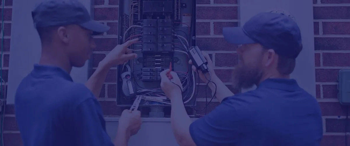 Two Next Electric Pro technicians working inside a residential electrical panel