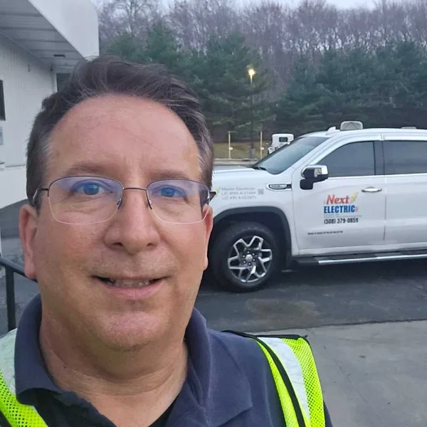 Raymond D. Melanson standing in front of a Next Electric Pro service truck